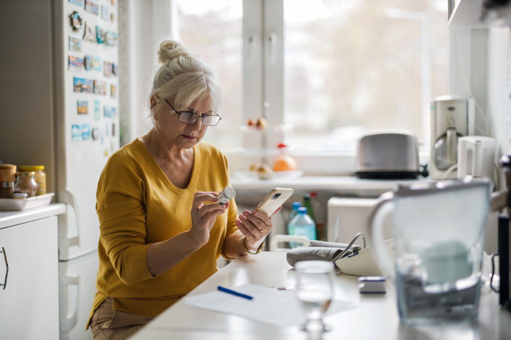 Older woman checking prescription with cell phone