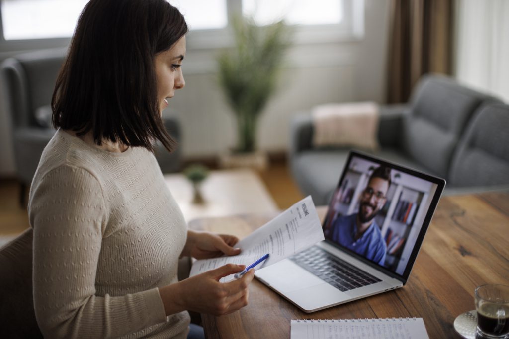 Woman reviewing a resume during a virtual job interview